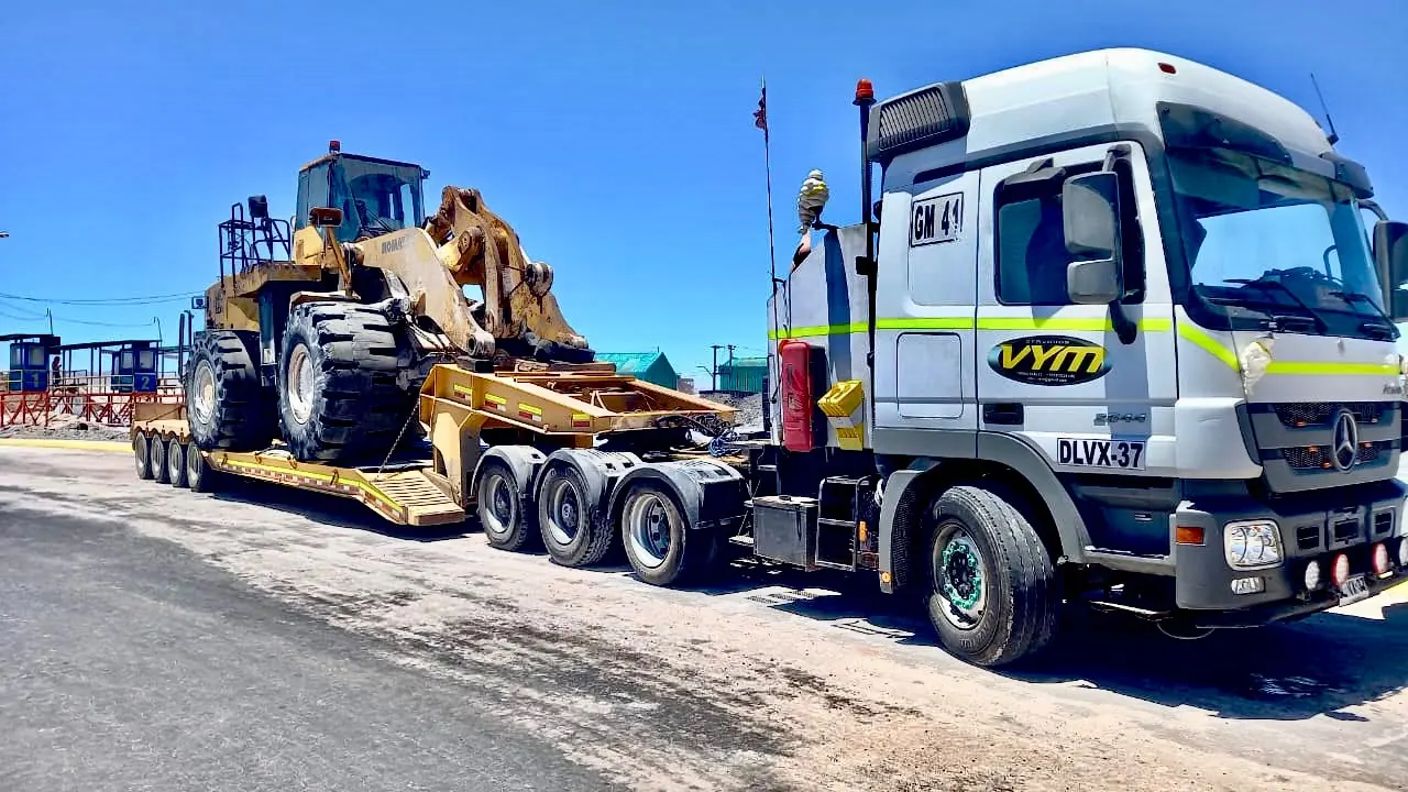 Camión transportando maquinaria pesada en carretera