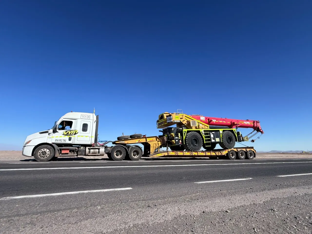 Camión trasladando maquinaria por carretera